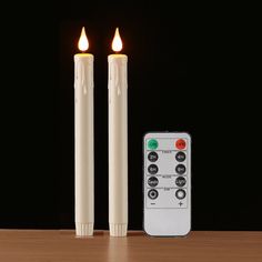 two candles with remote controls on a table