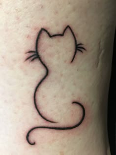 a small black cat tattoo on the right side of the leg, it has an outline of a cat's head and tail