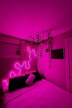 a bed in a room with pink lighting