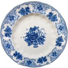 an ornate blue and white plate with flowers on the rim is displayed against a white background