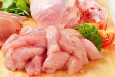 raw meat and vegetables on a cutting board