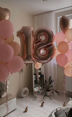 some balloons that are in the shape of the number twenty eight and one is pink