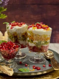 two desserts are on a tray with silverware and flowers in the back ground