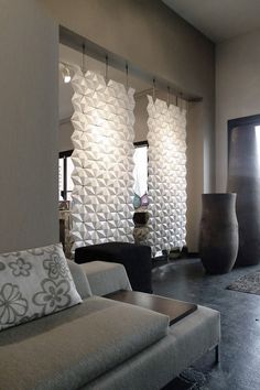 a living room filled with lots of furniture and walls covered in white paper flowers on the wall