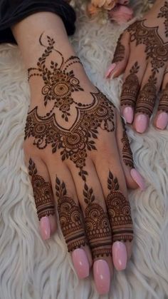 two hands with henna tattoos on them