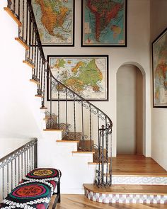 a stair case with maps on the wall above it