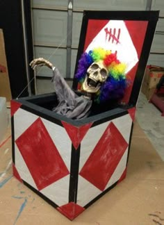 a box that has a skeleton in it with a clown's head on top