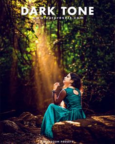 a woman sitting on top of a rock in the middle of a forest with sunlight coming through