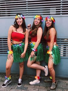 three young women in hula skirts posing for the camera