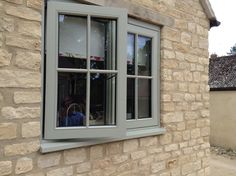 a man is looking out the window of a house that has stone walls and windows