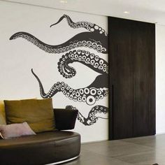 an octopus wall decal is on the wall in this modern living room with black and white accents