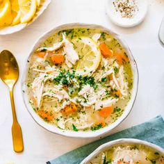 two bowls of chicken noodle soup with lemons and parsley on the side