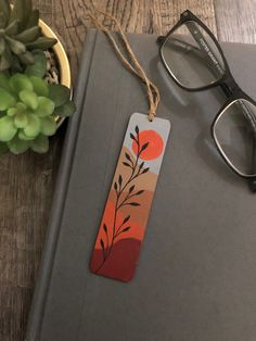 a pair of glasses sitting on top of a book next to a potted plant