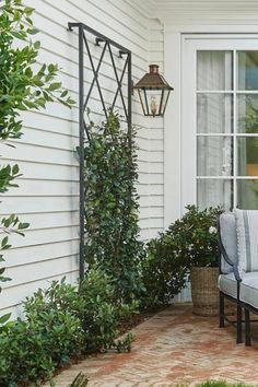 an outdoor patio with two chairs and a table on it, next to a window