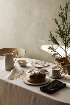 the table is set with bread, coffee and other breakfast foods for one person to eat