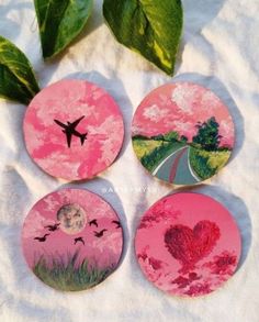 four pink coasters with images of trees, flowers and a plane flying over them