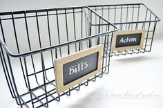 two metal baskets with wooden signs attached to them