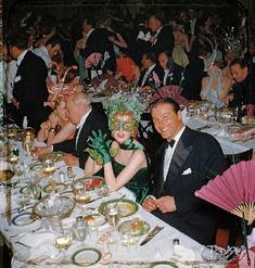 a group of people sitting at a table with plates and drinks in front of them