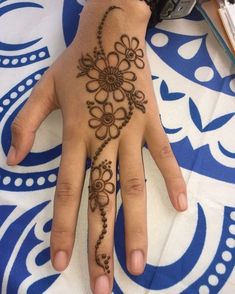 a woman's hand with henna tattoos on it