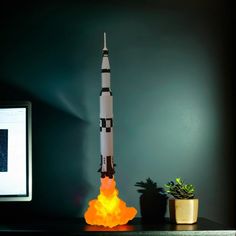 a toy rocket sitting on top of a desk next to a computer