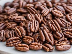 a pile of pecans sitting on top of a white plate