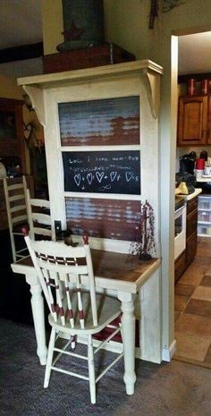 a kitchen with a chalkboard on the wall next to a wooden table and chairs