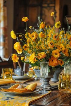 a table with yellow flowers in vases and napkins on the placemates