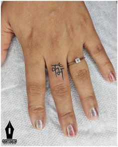 a woman's hand with a tattoo on her left thumb and the word love written in cursive writing