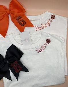 📣 Embroidered Collar Personalized Cheer Team Spirit T-Shirt  *Show off your team spirit with this super cute custom embroidered t-shirt!  It features your team or mascot name with a pom pom in your choice of thread colors. These are comfort colors brand t-shirts that are soft, comfy, and perfect for all of those cheer activities! 📣Want to add more of a personal touch?  Click the link to add-on personalized embroidery to the sleeve! https://buttonrosecreations.etsy.com/listing/1697746948/add-on-sleeve-embroidery-to-cheer-shirt 📣Be sure to check out my other listings for coordinating embroidered cheer shorts and bows! https://buttonrosecreations.etsy.com/listing/1712025707/custom-embroidered-cheer-bow-team-spiritT- https://buttonrosecreations.etsy.com/listing/1697643700/embroidered-girlsj White Embroidered T-shirt For College, Team Spirit T-shirt With Embroidered Graphics For Game Day, Game Day T-shirt With Embroidered Logo, Varsity Style Top With Embroidered Graphics For Fan Gear, Cotton Tops With Embroidered Graphics For Sports Events, Game Day Cotton Tops With Embroidered Logo, Team-colored Tops With Embroidered Graphics For Fans, Team-colored Tops With Embroidered Logo, Collegiate Embroidered Top For Game Day