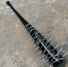 a black metal pole with spikes on it's end sitting on a concrete floor