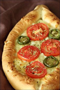 a pizza with tomatoes and green peppers on it