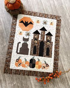 a quilted table runner with pumpkins and black cats on it