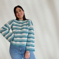 a woman standing in front of a white wall with her hands on her hips and smiling at the camera