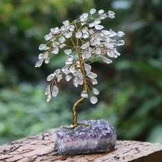 Joias do Rio Association brings us a stunning gemstone sculpture of a tree, symbolizing prosperity and wisdom. Brazilian artisans work on an amethyst base, adding brass wires to create the trunk and the branches. Then, they form the leaves using quartz gems, crystal-clear stones believed to enhance the spiritual qualities of their owner. Gemstone Sculpture, Gemstone Tree, Crystal Tree, Clear Stone, Amethyst Gemstone, The Holiday Aisle, A Tree, Crystal Clear, The Holiday