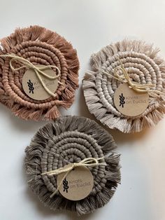 three round coasters with rope tied around them on a white surface, one has a tag that says knots on eulicity