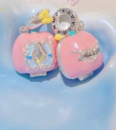 two pink purses with crowns on them sitting in a bathtub next to each other