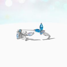 This ring is oh, so perfect. From the radiant array of blue crystals to the adjustable nature of the band, this ring has so many elements that only adds to it's elegance. Featuring a string of leaves on one end and a cute little butterfly on the other, our Perfect Petal Ring is just the piece to add to your garden of jewels. Adjustable Blue Crystal Wedding Ring, Elegant Adjustable Blue Flower Ring, Blue Adjustable Crystal Wedding Ring, Elegant Blue Adjustable Flower Ring, Adjustable Crystal Ring For Gift, Adjustable Light Blue Sterling Silver Rings, Blue Crystal Wedding Ring, Adjustable Blue Crystal Promise Ring, Blue Adjustable Crystal Promise Ring