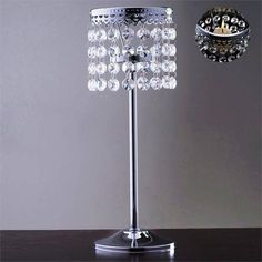 a crystal table lamp with a clock on the wall in the background and a candle holder