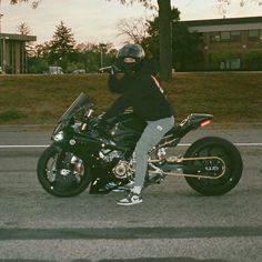 a man riding on the back of a black motorcycle