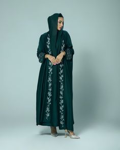 (Estimated delivery for pre-orders: 03/02/25 - 07/02/25. If you require a quicker delivery, please contact us). Giving elegant modesty, the 'Amani' abaya is perfect for all occasions. The satin fabric gracefully flows and is adorned with hand embellished intricate beading on the cuffs and collar. - Scarf and slip dress included. - Dry clean only. - Model is 5'6 wearing size 54. Elegant Long Sleeve Abaya With Embroidered Border, Formal Abaya With Dabka Work For Eid, Formal Eid Abaya With Dabka Work, Green Abaya With Dabka Work, Hand Embellished Long Sleeve Kaftan For Eid, Elegant Green Embroidered Thobe, Elegant Green Embroidered Abaya, Eid Embellished Green Abaya, Elegant Embroidered Green Abaya