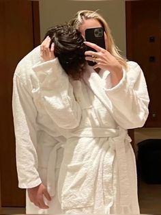 a woman taking a selfie in a bathrobe