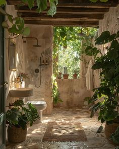 a bathroom with plants in the corner and a sink on the other side, surrounded by greenery