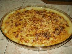 a cheese pizza sitting on top of a glass pan covered in sauce and toppings