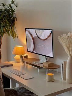 A cozy home office featuring a minimalist desk setup with neutral colors, warm lighting from a small lamp, a wooden monitor stand, and green plant decor, creating an elegant and serene workspace. Productive Work, Cozy Desk, Study Desk Decor, Cozy Office, Cozy Home Office, Deco Studio, Aesthetic Space, Warm Lighting, Office Room Decor