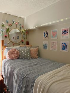 a small bedroom with a bed and pictures on the wall