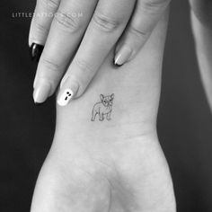 a small dog tattoo on the left inner wrist is shown in this black and white photo