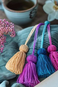 three tasselled beads are sitting on a table next to a cup of coffee