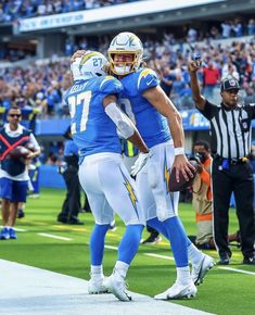 two football players are congratulating each other on the sidelines at a game