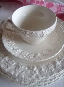 three white dishes sitting on top of each other next to a pink and white pillow