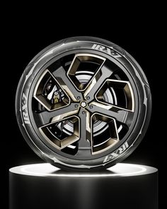 the front wheel of a car with lights on it's side and black background